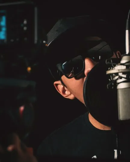 A presenter recording a piece to camera in a dark studio